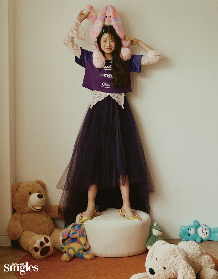 이해인이 익스파이어드걸의 럭비 티셔츠 푸쉬버튼과 레이스 블라우스, 손정완의 드레스, 로저비비에의 리본 장식 슬링백을 착용하고 촬영한 싱글즈 화보