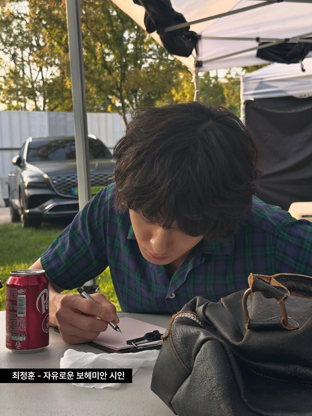 짙은 그린과 퍼플이 섞인 빈티치한 체크 소매 셔츠에 가죽 가방을 든 가수 잔나비 최정훈의 사진