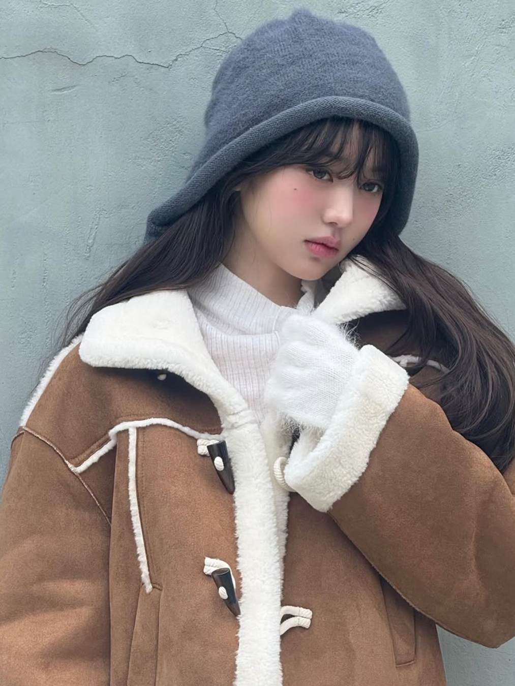 회색 니트 트루퍼햇을 쓰고 아이보리 목폴라, 카멜색 스웨이드 무스탕을 입은 아이브 장원영의 사진