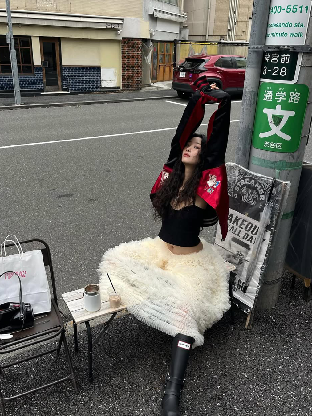 아이보리 컬러의 튜튜 스커트에 블랙 컬러 레인 부츠, 블록코어 윈드 브레이커 자켓을 입은 신지현의 사진