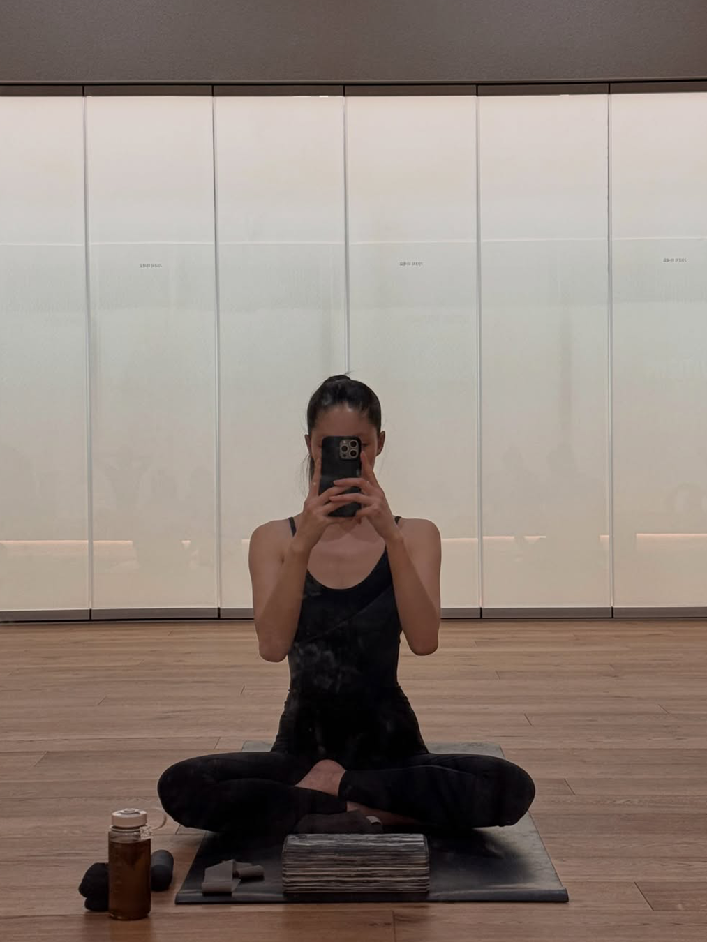 블랙 트레이닝복을 입고 요가 매트 위에서 운동을 하는 모델 윤이재의 사진