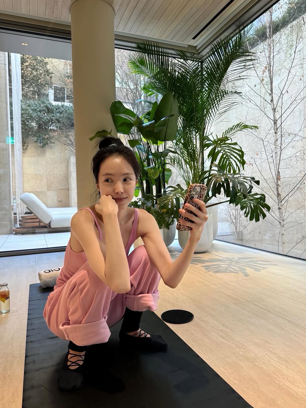 알로 핑크 트레이닝 셋업을 입고 요가 매트 위에 있는 손나은