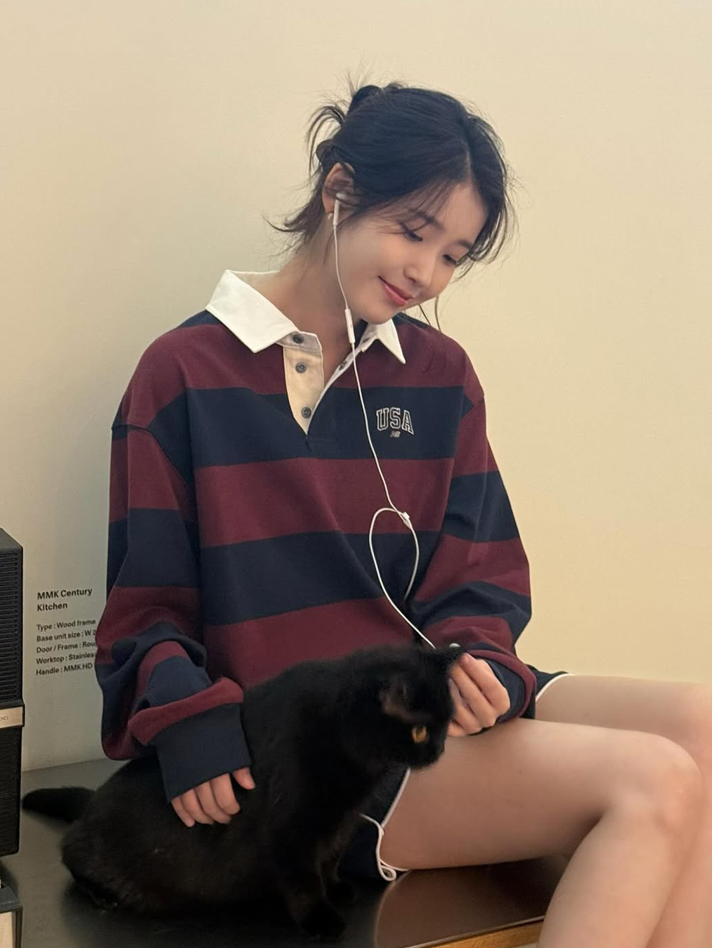 와인 컬러와 네이비 컬러가 조합된 스트라이프 럭비 티셔츠를 입고 줄 이어폰을 꽂은 아이유의 사진